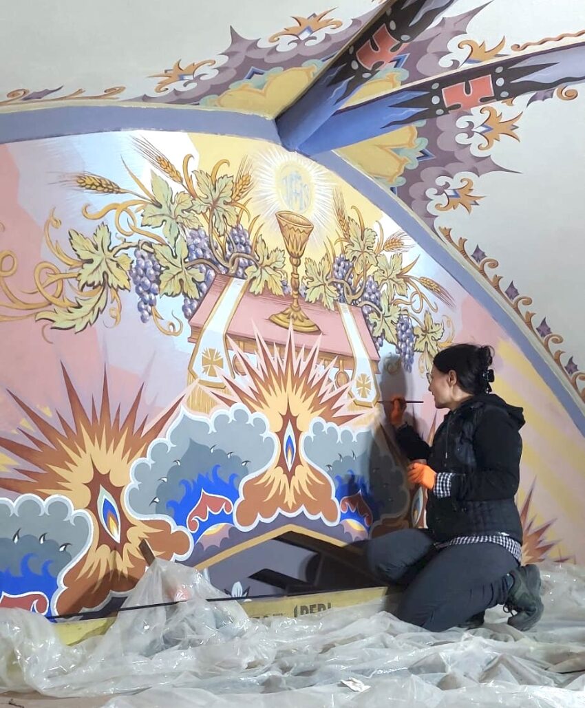 A person retouching polychromes of a religious kind